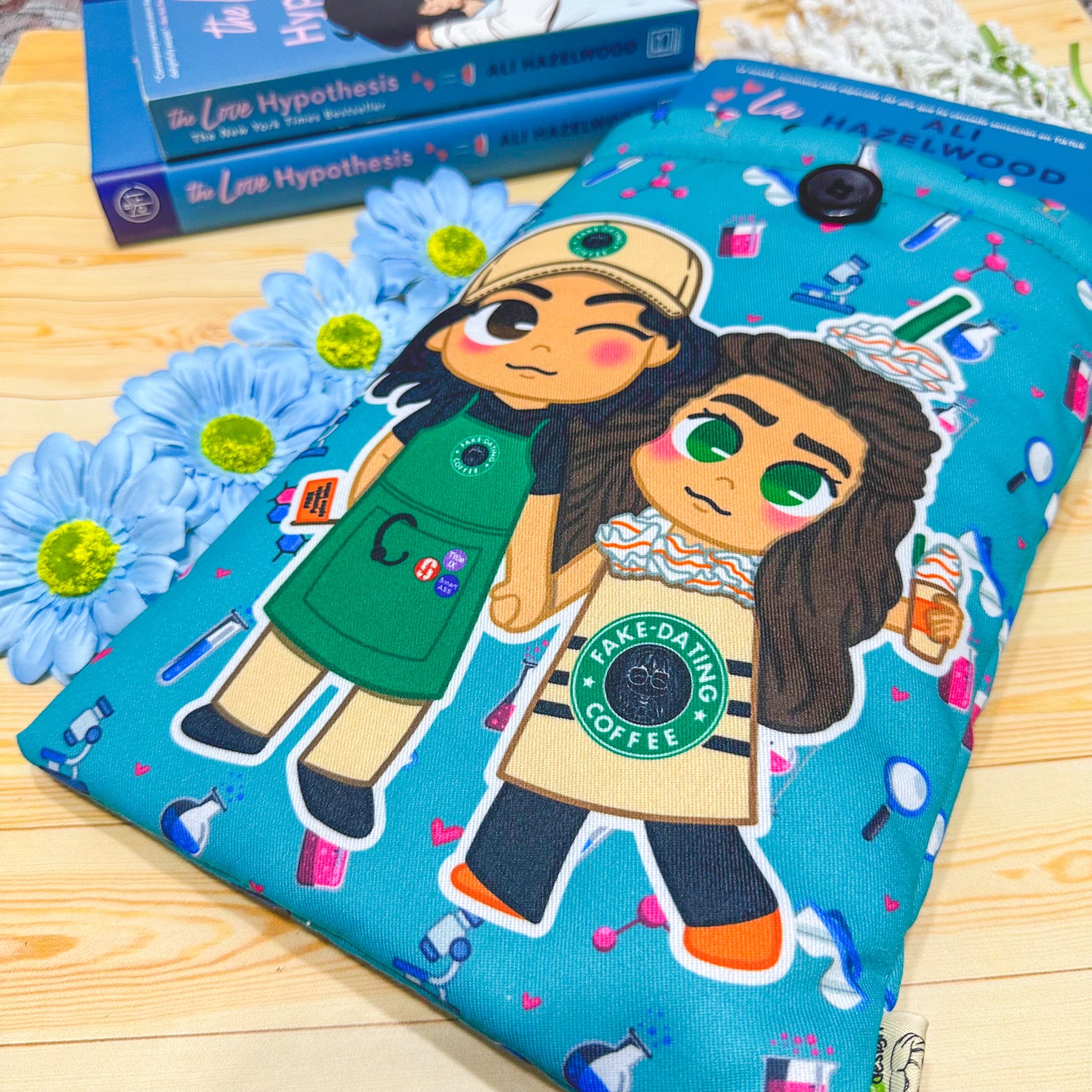 A padded book sleeve with vibrant designs inspired by Ali Hazelwood's novels, featuring romantic and STEM-themed illustrations of chibi-style characters.