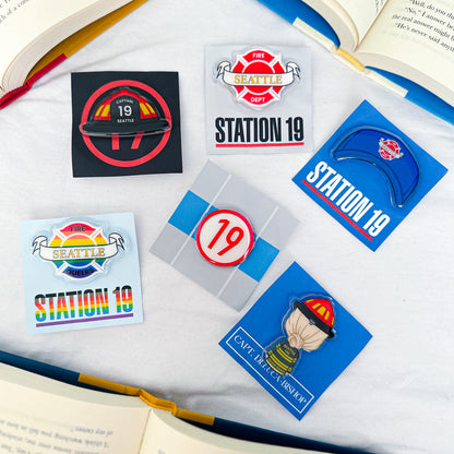 Acrylic pins inspired by Station 19, showcasing fire-themed elements and character illustrations.